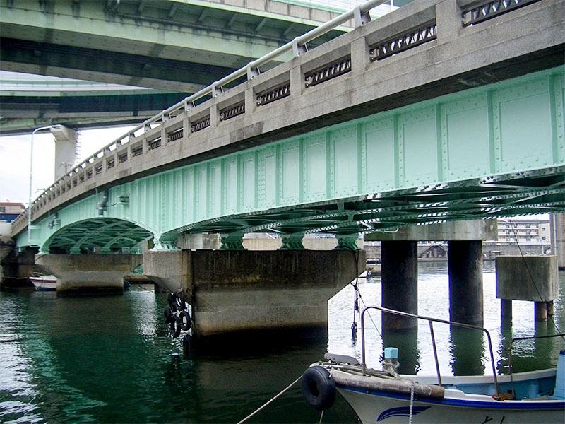 河川に架かる鋼橋の重防食塗装による補修工事完了後の全景